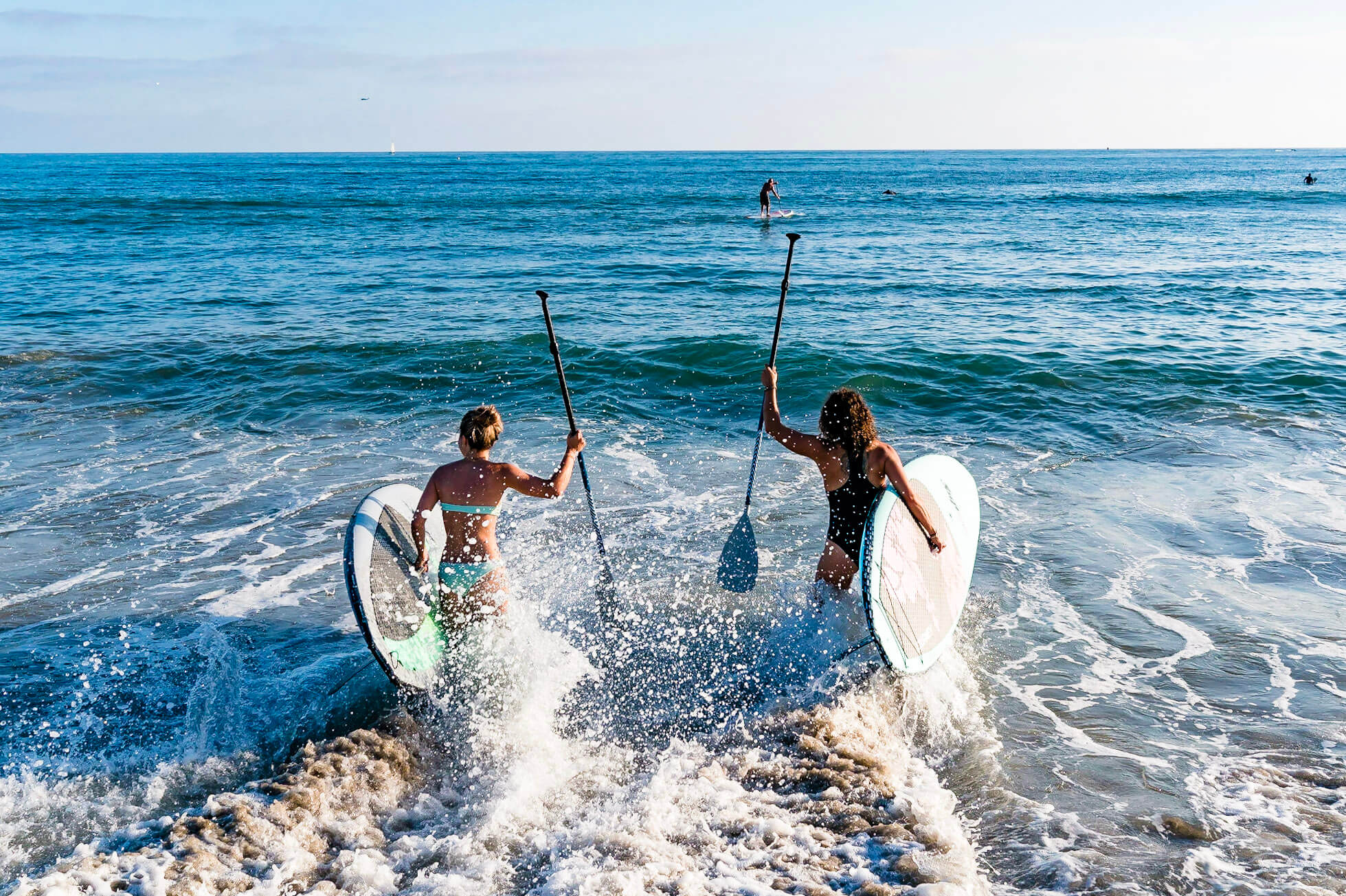 two people paddle boarding in dana point
