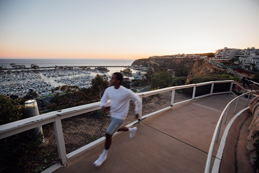 Man Running with ocean behind him at the Dana Point Bluff Top Trails